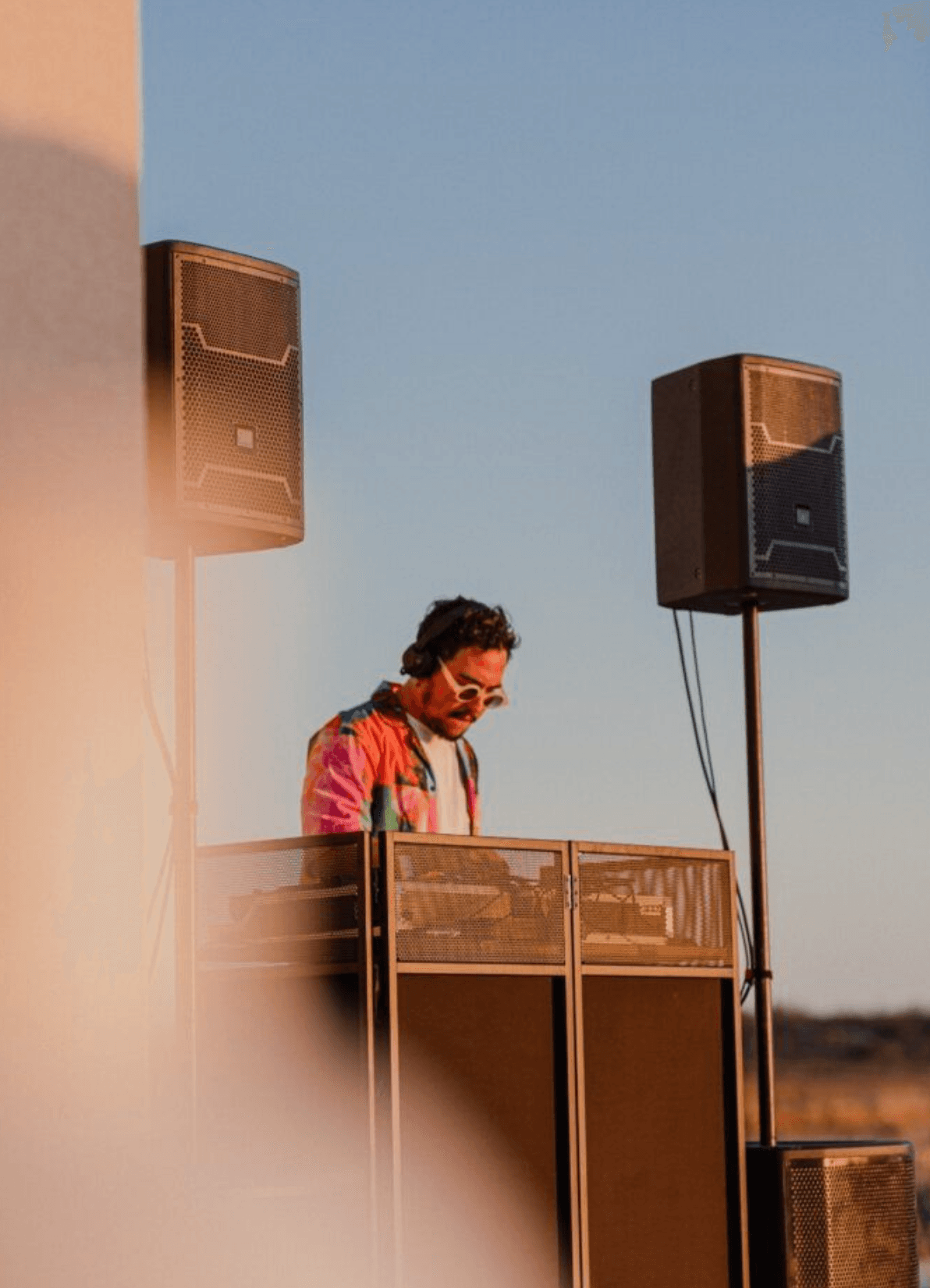 Rooftop DJ set with city skyline at sunset